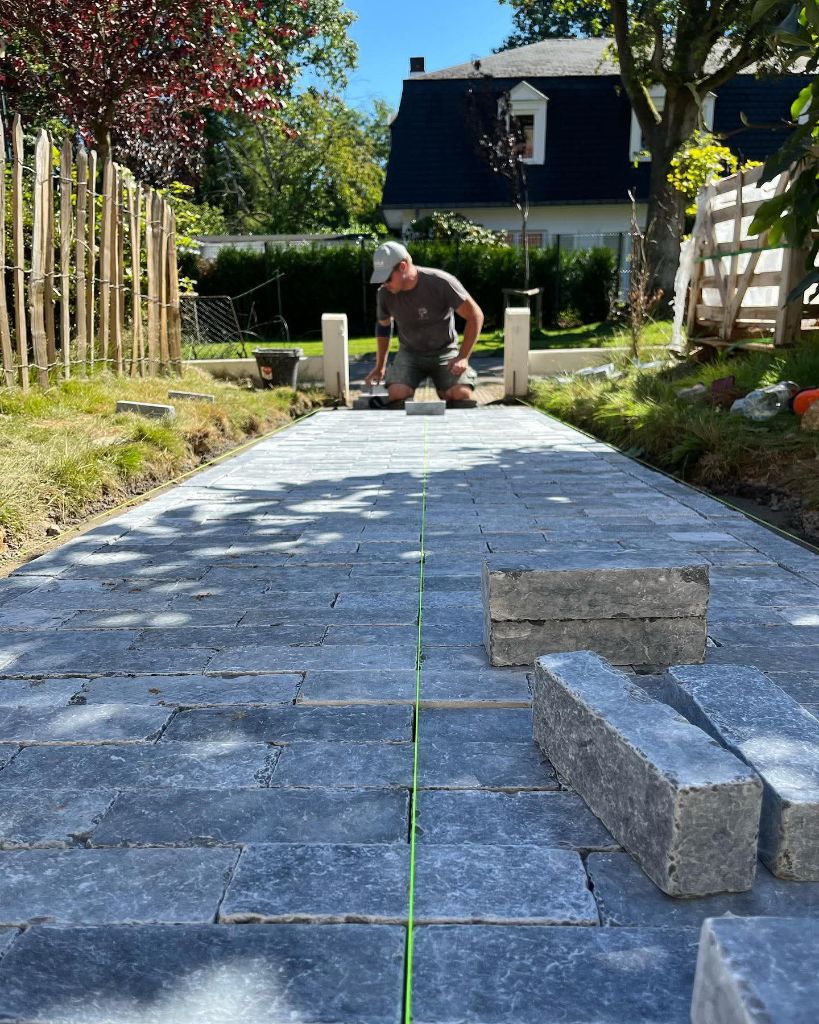 Pose d'un chemin pavé en cours de réalisation